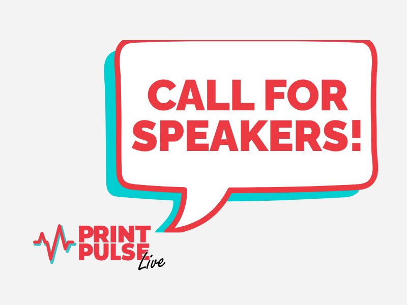 Three professionals of diverse backgrounds engaged in a meeting, discussing documents and digital content at a conference table in a bright office setting.