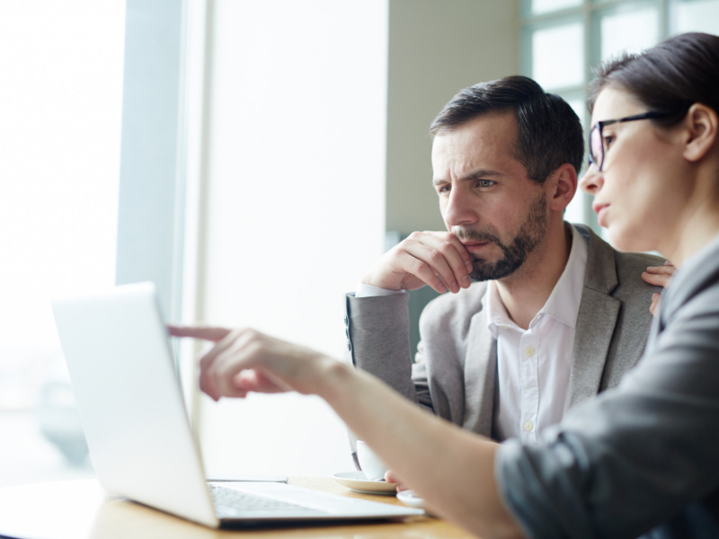 Business leaders review options on a laptop while assessing tariff response decisions and sourcing flexibility.